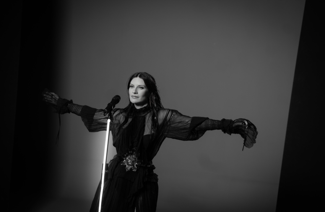 Laura Pausini en el videoclip de “Mariposa Tecknicolor”, rodeada de mariposas vibrantes tecknicolor en un escenario romano dinámico, simbolizando transformación y libertad. ​