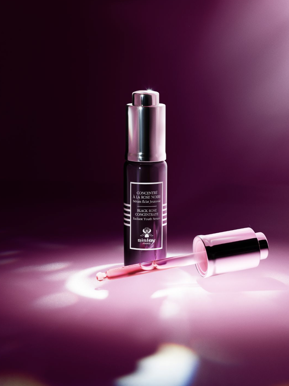Frasco rosado del Black Rose Concentrate Radiant Youth Serum de Sisley, serum con extracto de Rosa Negra para luminosidad juvenil y piel radiante.