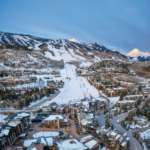 Vista panorámica de Snowmass Village, el pueblo de ski cerca de Aspen Snowmass en Colorado: hoteles, resorts y montañas nevadas bajo sol primaveral. Temporada ski hasta abril 2026.