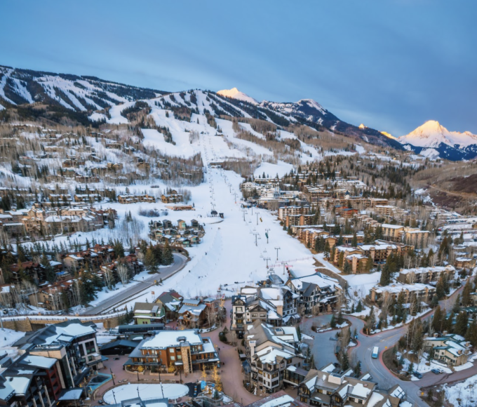 Vista panorámica de Snowmass Village, el pueblo de ski cerca de Aspen Snowmass en Colorado: hoteles, resorts y montañas nevadas bajo sol primaveral. Temporada ski hasta abril 2026.