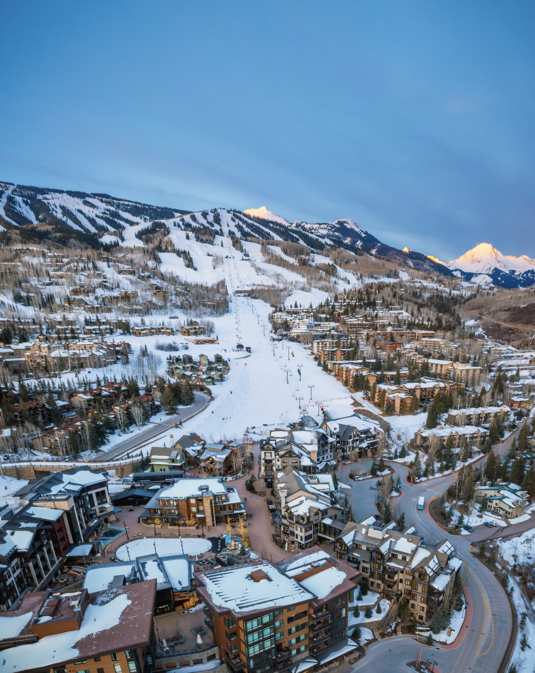 Vista panorámica de Snowmass Village, el pueblo de ski cerca de Aspen Snowmass en Colorado: hoteles, resorts y montañas nevadas bajo sol primaveral. Temporada ski hasta abril 2026.