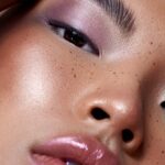 Tendencias belleza FW 2026 en pasarela: colores vibrantes translúcidos, blush melocotón y glass skin luminosa inspirada en Dior.