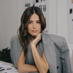 Mujer de estilo contemporáneo, vestida con prendas de simple luxury de Ellaz, posando en un espacio minimalista, representando la nueva era creativa de la marca bajo la dirección de Paola Alberdi.