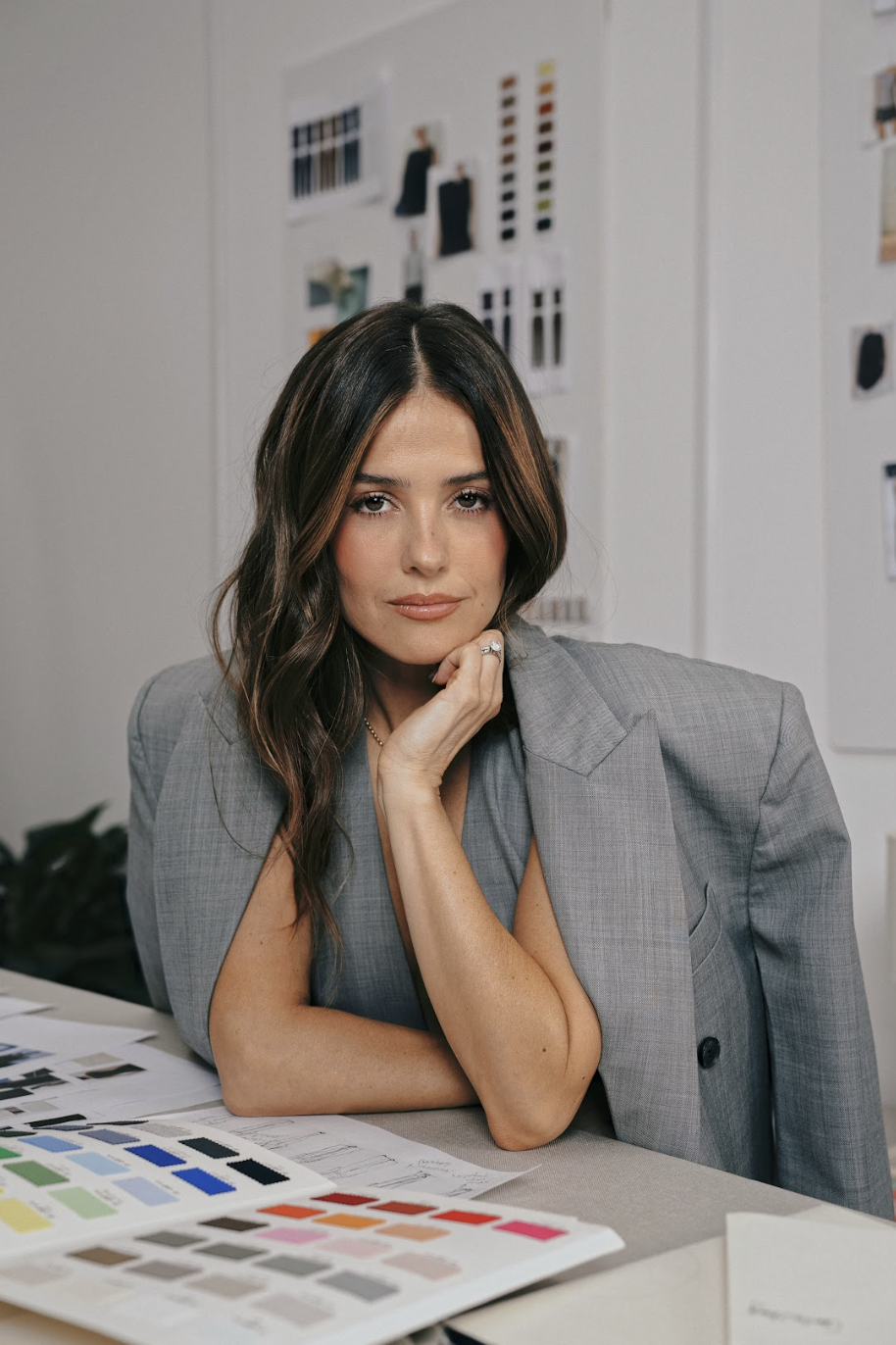 Mujer de estilo contemporáneo, vestida con prendas de simple luxury de Ellaz, posando en un espacio minimalista, representando la nueva era creativa de la marca bajo la dirección de Paola Alberdi.