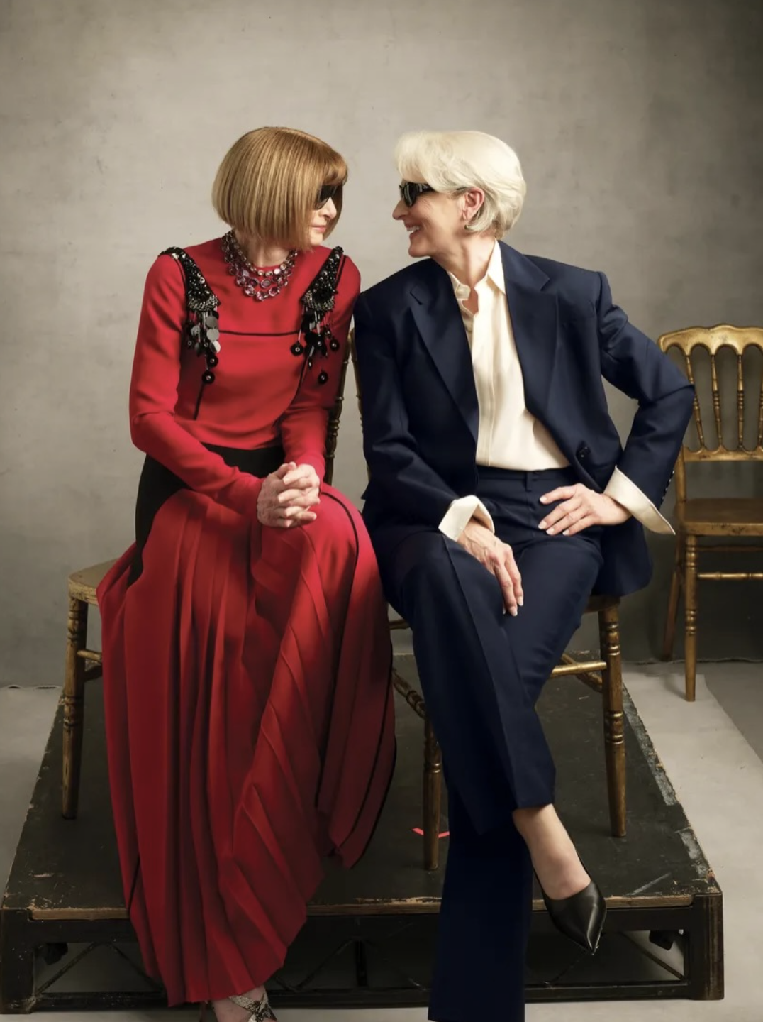 Meryl Streep y Anna Wintour en la portada de Vogue mayo 2026, vestidas de Prada. La actriz de Miranda Priestly luce traje azul marino oversized, camisa crema y gafas oscuras; la editora, look elegante. Imagen icónica de cine y moda.