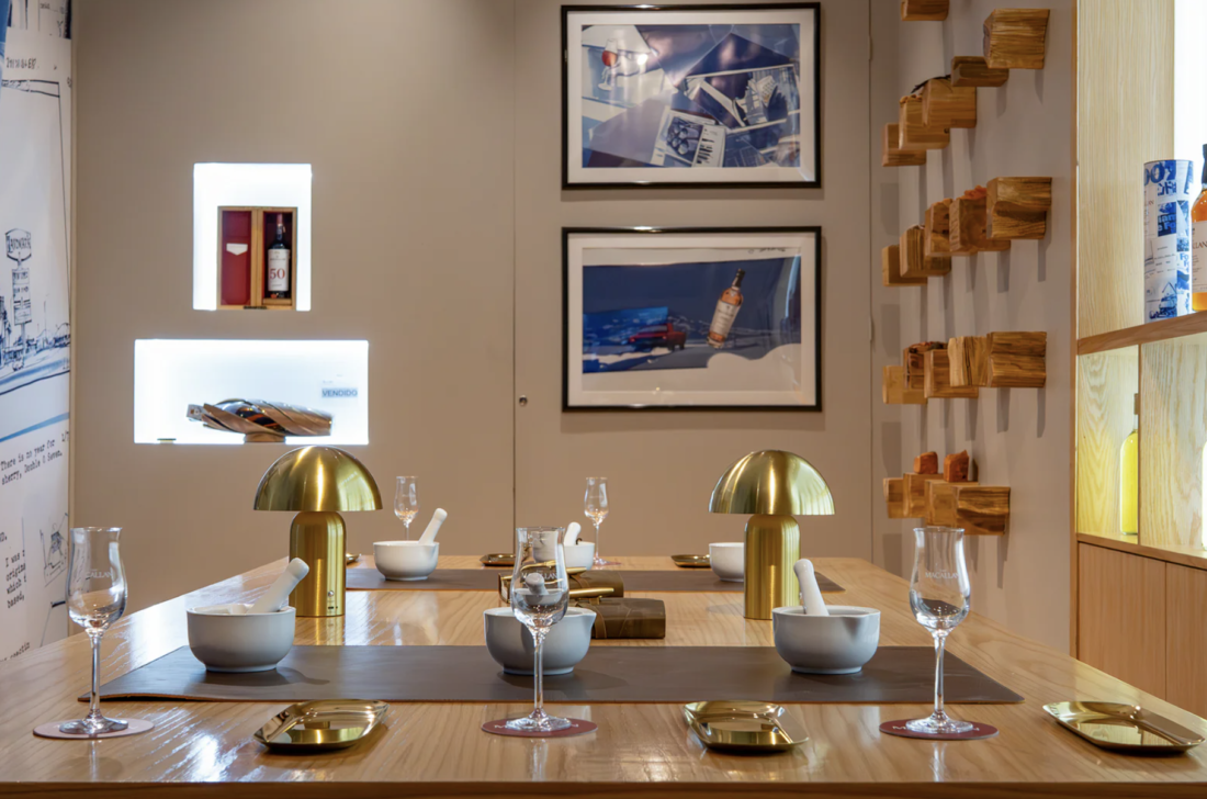 Interior elegante de la pop-up de The Macallan en Palacio de Hierro Polanco, inspirada en Diamonds Are Forever de James Bond, con botellas de whisky premium, diseño inmersivo y elementos cinematográficos de lujo.