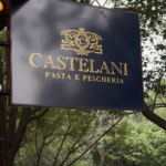 Interior del restaurante Castelani Pasta e Pescheria en Polanco, con una mesa servida de cocina italiana contemporánea que incluye ravioles de calamar y risotto de parmesano, en un ambiente elegante y sofisticado.