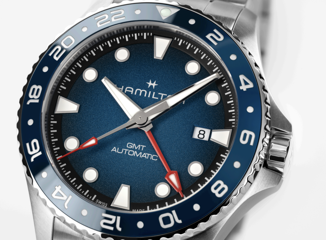 Relojes Hamilton Khaki Navy Scuba Auto 40 mm y Scuba Auto GMT en acero inoxidable, con esfera azul y bisel giratorio, presentados sobre un fondo de inspiración marina.