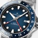 Relojes Hamilton Khaki Navy Scuba Auto 40 mm y Scuba Auto GMT en acero inoxidable, con esfera azul y bisel giratorio, presentados sobre un fondo de inspiración marina.