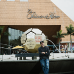 Román de Castro posa junto a su intervención artística para La Fiesta Está en El Palacio, una obra monumental inspirada en un balón de fútbol que reflexiona sobre la perseverancia y la memoria colectiva.
