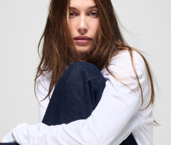 Hailey Bieber posa con prendas de la colección The Hailey Jean para Gap, luciendo jeans de inspiración noventera y una camiseta blanca en la campaña de edición limitada.