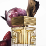 Frasco de Destin de Balmain, una fragancia floral-frutal de lujo, presentado en un diseño cúbico de vidrio transparente con detalles dorados y el icónico motivo de laberinto de Balmain.