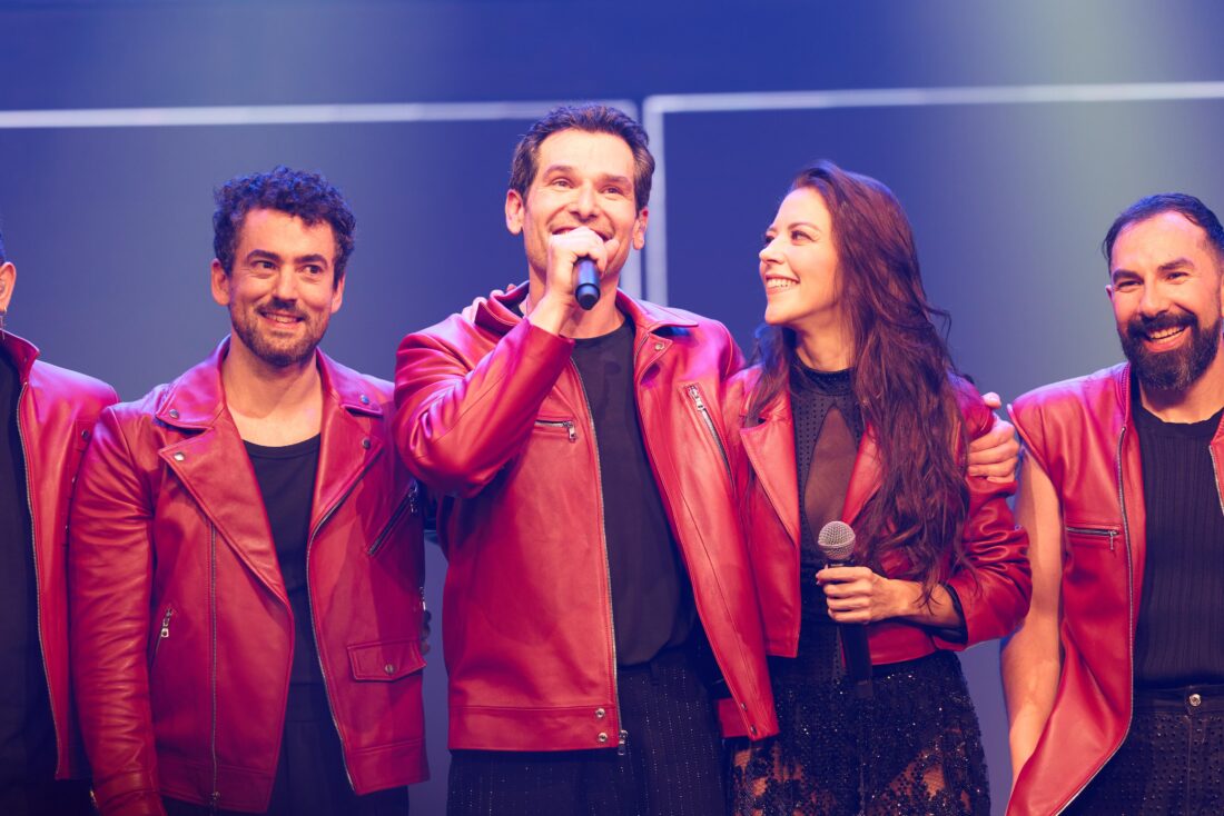 El elenco de Hoy No Me Puedo Levantar luce las chamarras rojas de piel hechas a mano por DANCASSAB durante el último acto del musical.