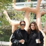 Dos mujeres toman café en la plaza del proyecto Atlantis CDMX